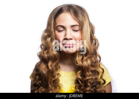 Porträt von glücklich geschlossenen Augen Mädchen mit welligen Frisur und gelben t-Shirt. Studio gedreht isolierten auf weißen Hintergrund. Stockfoto