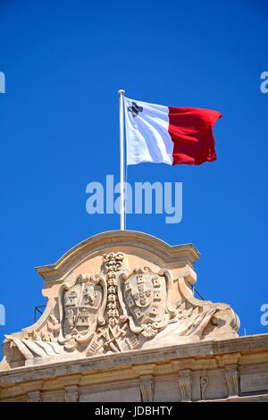 Maltesischer Flagge und Küste von Waffen auf die Auberge de Castille in Castille Square, Valletta, Malta, Europa. Stockfoto