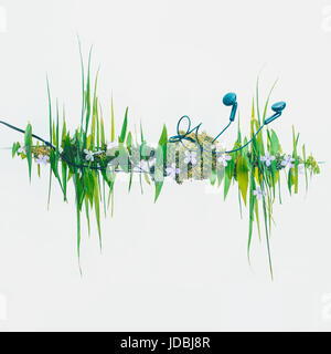 Konzeptionelle Foto mit Schallwelle-Grafik, die aus Blättern und Rasen aus. Kopfhörer mit Musik der Natur. Stockfoto