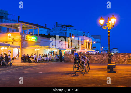 Sardinien Tourismus, Touristen in der sardischen Resort von Alghero Speisen im Freien an einem Sommerabend in den Restaurants entlang der Strandpromenade in der Altstadt. Stockfoto