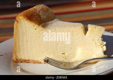 Stück frischen traditionellen Souffle Käsekuchen auf weißen Teller mit Gabel auf Tisch, Nahaufnahme, niedrigen Winkel-Seitenansicht Stockfoto