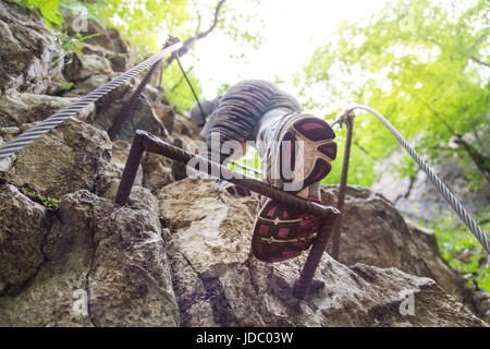 Sportlich aktive Frau, die auf dem felsigen Weg den Berg hinauf klettern. Auf der Sohle des Sportschuhs konzentrieren. Stockfoto