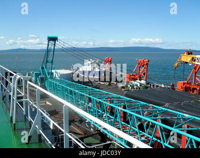 Das Deck legen Lastkahn. Rohre und heben Kräne auf dem Schiff. Ausrüstung für die Verlegung einer Pipeline auf dem Meeresboden. Stockfoto