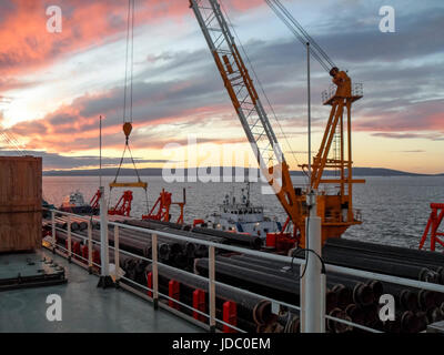 Das Deck legen Lastkahn. Rohre und heben Kräne auf dem Schiff. Ausrüstung für die Verlegung einer Pipeline auf dem Meeresboden. Stockfoto