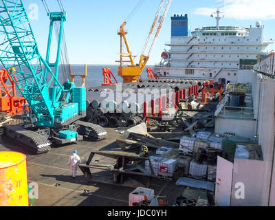 Das Deck legen Lastkahn. Rohre und heben Kräne auf dem Schiff. Ausrüstung für die Verlegung einer Pipeline auf dem Meeresboden. Stockfoto