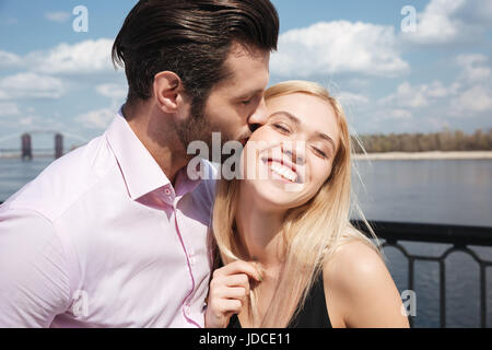 Schönen jungen Mann offizielle Hemd küssen seine hübsche blonde Frau Stockfoto