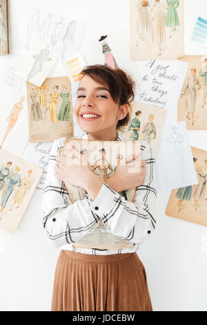 Schöne junge Frau Fahion Designer halten ihr Skizzenbuch im studio Stockfoto