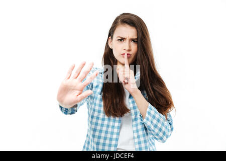 Junge Brünette Mädchen im karierten Hemd zeigt stille Geste isoliert über weißen unzufrieden Stockfoto