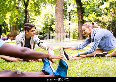 Gruppe von jungen Läufer dehnen und Aufwärmen im Park. Stockfoto