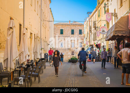 Alghero Sardinien Straße auf einem Sommer-Morgen-Leute Fuß entlang einer Straße in der Nähe der Porta Terra in der Altstadt von Alghero, Sardinien. Stockfoto