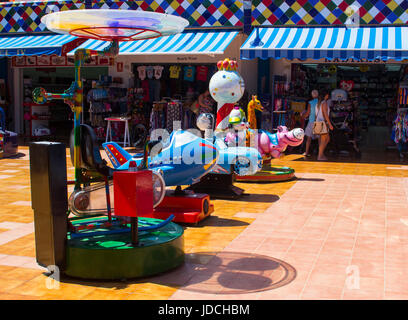 Eine Auswahl an bunten Elektro sitzen auf Fahrten für Säuglinge und Kleinkinder in einem Vergnügungszentrum in einem örtlichen Einkaufszentrum in Playa Las Americas ich Stockfoto