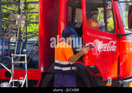 Ein paar männliche Mitarbeiter machen eine Lieferung von Coca Cola zu einem lokalen Supermarkt in Playa Las Americas in der Kanarischen Insel Teneriffa Stockfoto