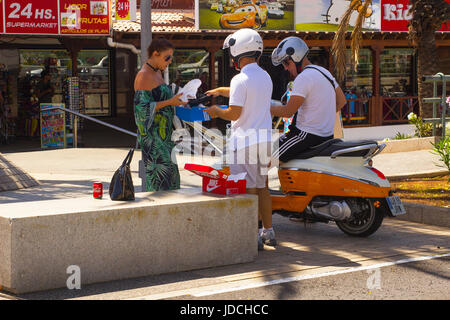 Eine glamouröse junge Dame unterhielt sich mit zwei männlichen Motorradfahrer auf der Hauptstraße von Playa Las Americas in Teneriffa Stockfoto