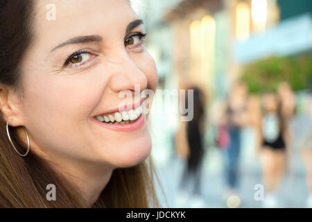 Porträt einer Frau lächelnd, fröhlich, an der Kamera, closeup suchen, im freien Hintergrund. Stockfoto