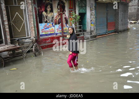 Dhaka, Bangladesch. 19. Juni 2017. Bürgerinnen und Bürger zu Fuß durch die überfluteten Straßen von Dhaka nach heftigen Regenfällen verursacht fast-Stillstand, auf June19, 2015. Nach schweren Monsun überflutet Regenfälle verursacht die meisten des Bereichs in der Hauptstadt Dhaka in Bangladesch. Straßen wurden teilweise unter Wasser machen Reisen gefährlich. Eine Reihe von Fahrradrikschas hob im Wasser. Bildnachweis: Mamunur Rashid/Alamy Live-Nachrichten Stockfoto