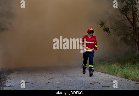 Lissabon, Portugal. 19. Juni 2017. Ein Feuerwehrmann zieht sich wie ein Waldbrand außerhalb Derreada Cimeira, einer Stadt etwa 180 km nordöstlich von Lissabon, Portugal, 19. Juni 2017 ausbreitet. Die portugiesische Polizei haben erklärt, dass eine Reihe von tödlichen Waldbrände durch einen Blitzschlag ausgelöst wurden. Foto: Peter Kneffel/Dpa/Alamy Live News Stockfoto