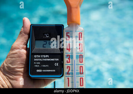 Ein Bademeister misst die Temperatur des Wassers, derzeit bei 24,3 Grad Celsius, in einem öffentlichen Freibad in Nürnberg, 20. Juni 2017. Ein anderes Thermostat zeigt die Luft-Temperatur von 34 Grad Celsius. Foto: Daniel Karmann/dpa Stockfoto