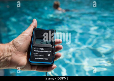 Ein Bademeister misst die Temperatur des Wassers, derzeit bei 24,3 Grad Celsius, in einem öffentlichen Freibad in Nürnberg, 20. Juni 2017. Foto: Daniel Karmann/dpa Stockfoto