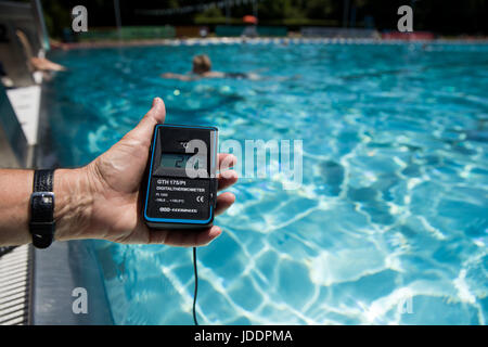 Ein Bademeister misst die Temperatur des Wassers, derzeit bei 24,3 Grad Celsius, in einem öffentlichen Freibad in Nürnberg, 20. Juni 2017. Foto: Daniel Karmann/dpa Stockfoto