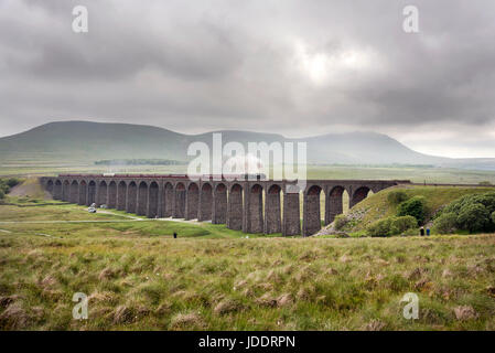 Ingleborough, UK. 20. Juni 2017. An einem bewölkten Sommertag kreuzt die Dalesman Dampf Ausflug Batty Moss (oder Ribblehead) Viadukt auf der Settle Carlisle Eisenbahnlinie nach Norden Carlisle, 20. Juni 2017. Im Hintergrund schwebt die Wolke über Ingleborough, eines der berühmten drei Zinnen der Yorkshire Dales. Bildnachweis: John Bentley/Alamy Live-Nachrichten Stockfoto