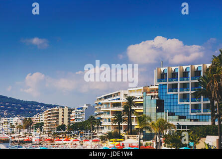 JUAN LES PINS, Frankreich - 20. September 2016: Hotels und Französisch Strand mit bunten Sonnenschirmen in Juan-Les-Pins an der französischen Riviera gedreht Stockfoto