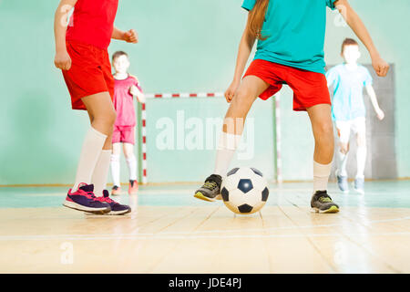 Fußballspieler schießen ein Tor beim Spiel in Futsal, close-up der Beine Stockfoto