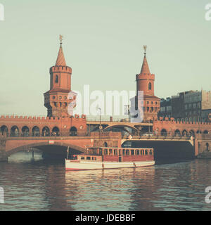 Oberbaumbrücke und Boot auf der Spree - Oberbaumbruecke in Berlin, Deutschland Stockfoto