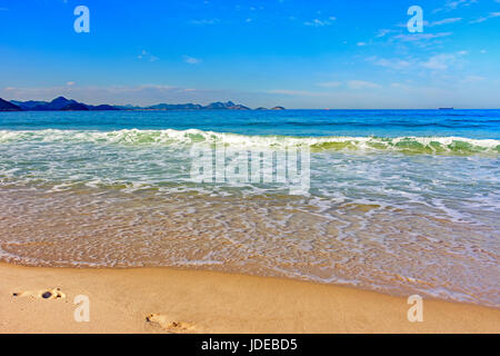 Wasser über Sand in Cpacabana Strand Horizont mit Rio De Janeiro Hügel Stockfoto