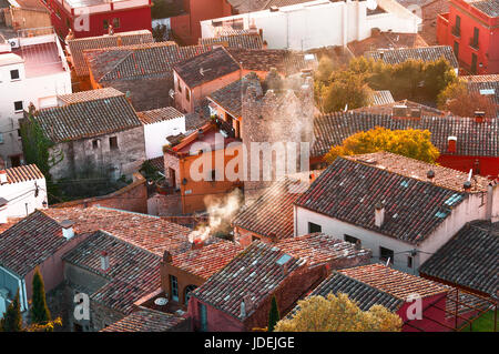 Draufsicht einer kleinen Stadt in Spanien, Begur. Detailansicht der traditionellen europäischen Stadt Dächer und Häuser. Rauchende Schlote in Stadt. Stockfoto