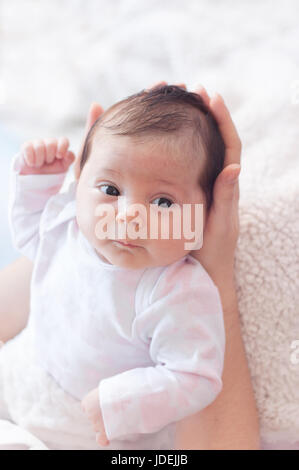 Sanft Mutter Hände halten Baby. Prall und schön Neugeborenen starrt auf ihre Mutter. sanfte. Stockfoto