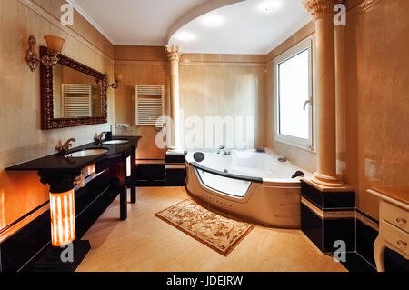 Luxuriöses Badezimmer im klassischen Stil mit korinthischen Säulen. Badezimmer mit zwei Waschbecken und einem Whirlpool.  Die Böden und Wände mit Marmor. Stockfoto
