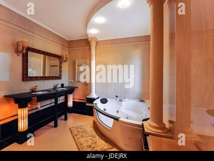 Luxuriöses Badezimmer im klassischen Stil mit korinthischen Säulen. Badezimmer mit zwei Waschbecken und einem Whirlpool.  Die Böden und Wände mit Marmor. Stockfoto