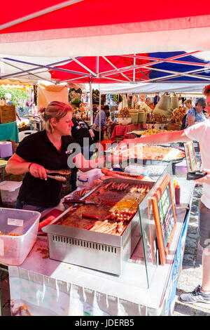 Französische warmes Essen am Markt in Sandwich Stadt ausgeht, Le Wochenende Veranstaltung. Frau das Geld vom Kunden über Fach von verschiedenen Arten von gekochten Würstchen. Stockfoto