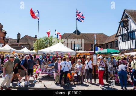 Französischen Markt Veranstaltung außerhalb des 15. Jahrhunderts guildhall in der englischen Stadt, Sandwich. Französische und britische Fahnen, Marktständen, und die Menschen im hellen Sonnenschein. Stockfoto