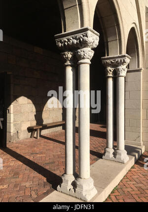 Mittelalterliche Kolonnade aus dem 12. Jahrhundert BCE. Am späten Nachmittag mit langen Schatten. Kreuzgang von einer mittelalterlichen Kirche, wärmende Sonnenstrahlen und lange Schatten. Stockfoto