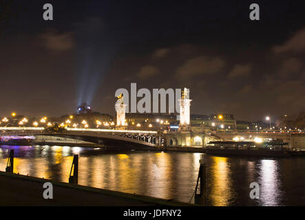 Nachtansicht des Grand Palais (Palast), Brücke Pont Alexandre III und und Seineufer in Paris. Stockfoto