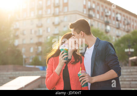 Jugendliche trinken Obst frisch aus Gläsern. Einen bescheidenen ersten Kuss. Paar in der Liebe. Romantik der ersten Liebe. Stockfoto