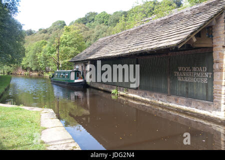 Ein Narrowboat neben Wolle Straße Umschlag Lager auf der Huddersfield Narrow Canal, Uppermill, Oldham, Lancashire, England, Vereinigtes Königreich Stockfoto