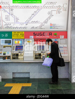 Unbekannter Mann kauft Ticket Automaten am Bahnhof Hakata in Fukuoka, Japan Stockfoto