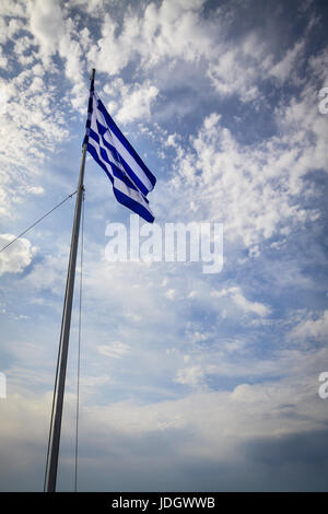 Nationalflagge Griechenlands am sonnigen Tag und teilweise bewölkter Himmelshintergrund. Stockfoto