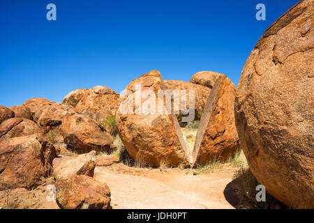 Devils Marbles - Felsen aus rotem Granit sind auf Grundgestein, Australien, Northern Territory ausgeglichen. Stockfoto