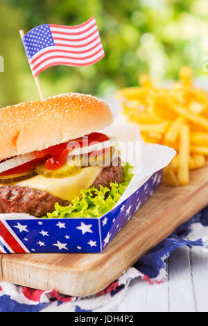 Ein leckerer Burger mit Pommes Frites auf einen Tisch im Freien. Stockfoto