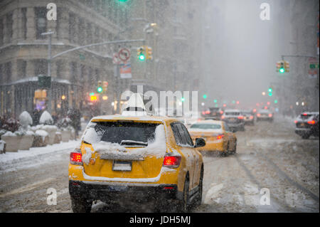 Ein Schneesturm Winter bringt Verkehr und Fußgänger zu einem langsamen schleichen im Flatiron Building an der Fifth Avenue. Stockfoto