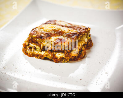 Lasagne Bolognese. Typische hausgemachte frische grüne Nudeln gekocht im Ofen. Ein Teil in der Platte. Stockfoto
