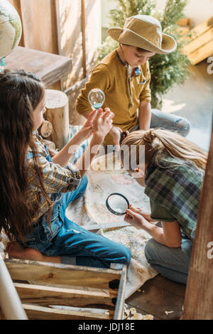 niedlichen Kinder spielen Schatzsuche mit Karte auf Veranda Stockfoto