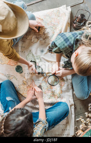 niedlichen Kinder spielen Schatzsuche mit Karte auf Veranda Stockfoto