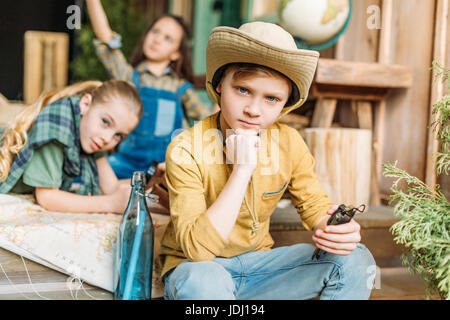 niedlichen Kinder spielen Schatzsuche mit Karte auf Veranda Stockfoto