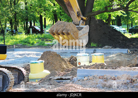 Bagger gräbt Kunststoff-Tank Gas-Öl-Catcher im Boden beim Bau eines Parkhauses für Touristenbusse, Russland Stockfoto