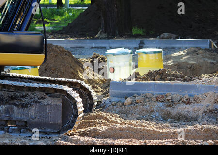 Bagger gräbt Kunststoff-Tank Gas-Öl-Catcher im Boden beim Bau eines Parkhauses für Touristenbusse, Russland Stockfoto