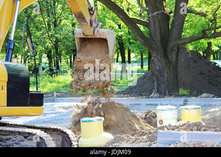 Bagger gräbt Kunststoff-Tank Gas-Öl-Catcher im Boden beim Bau eines Parkhauses für Touristenbusse, Russland Stockfoto